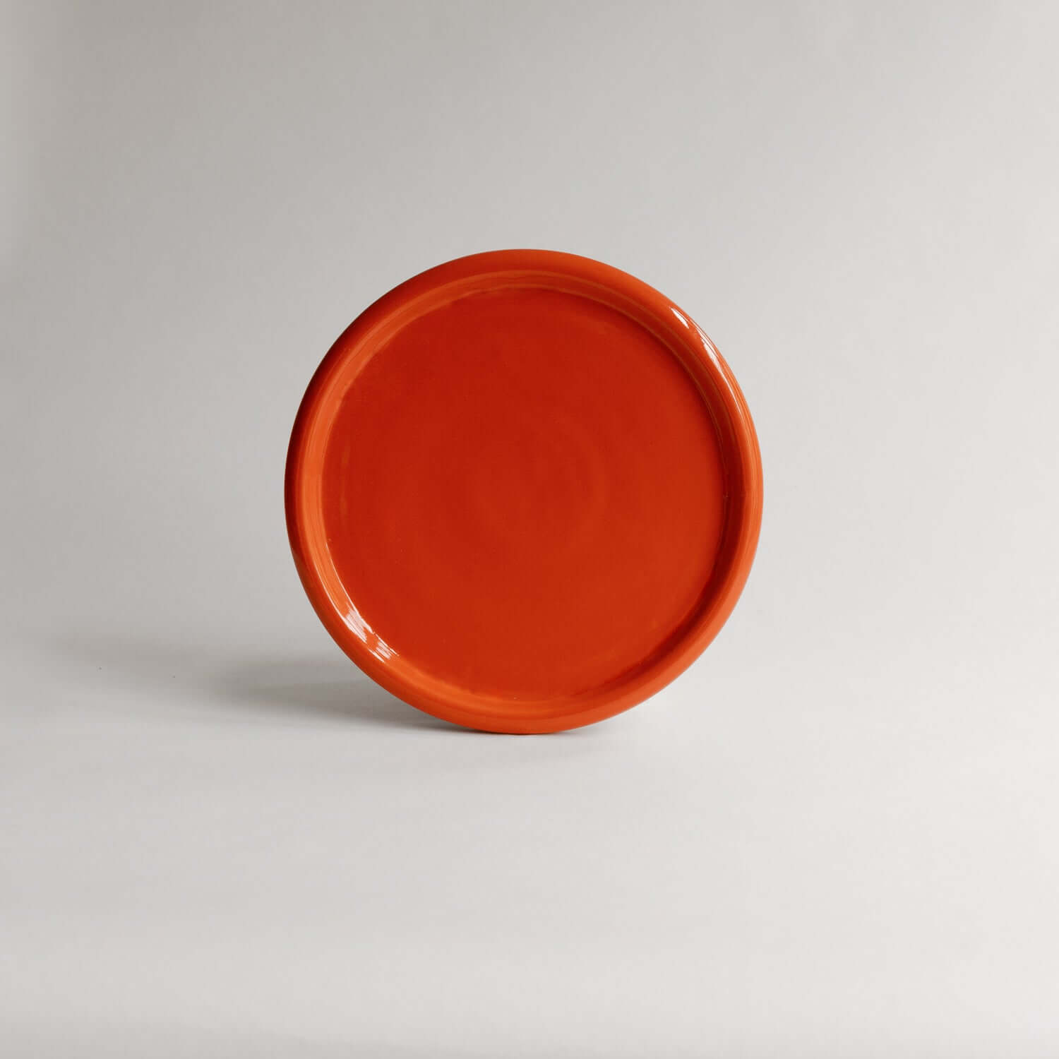 Explore the Plate Aleah Red, 19cm of artisanal charm in grey stoneware with a vibrant red finish. Embrace the uniqueness of handmade. von viola beuscher ceramics